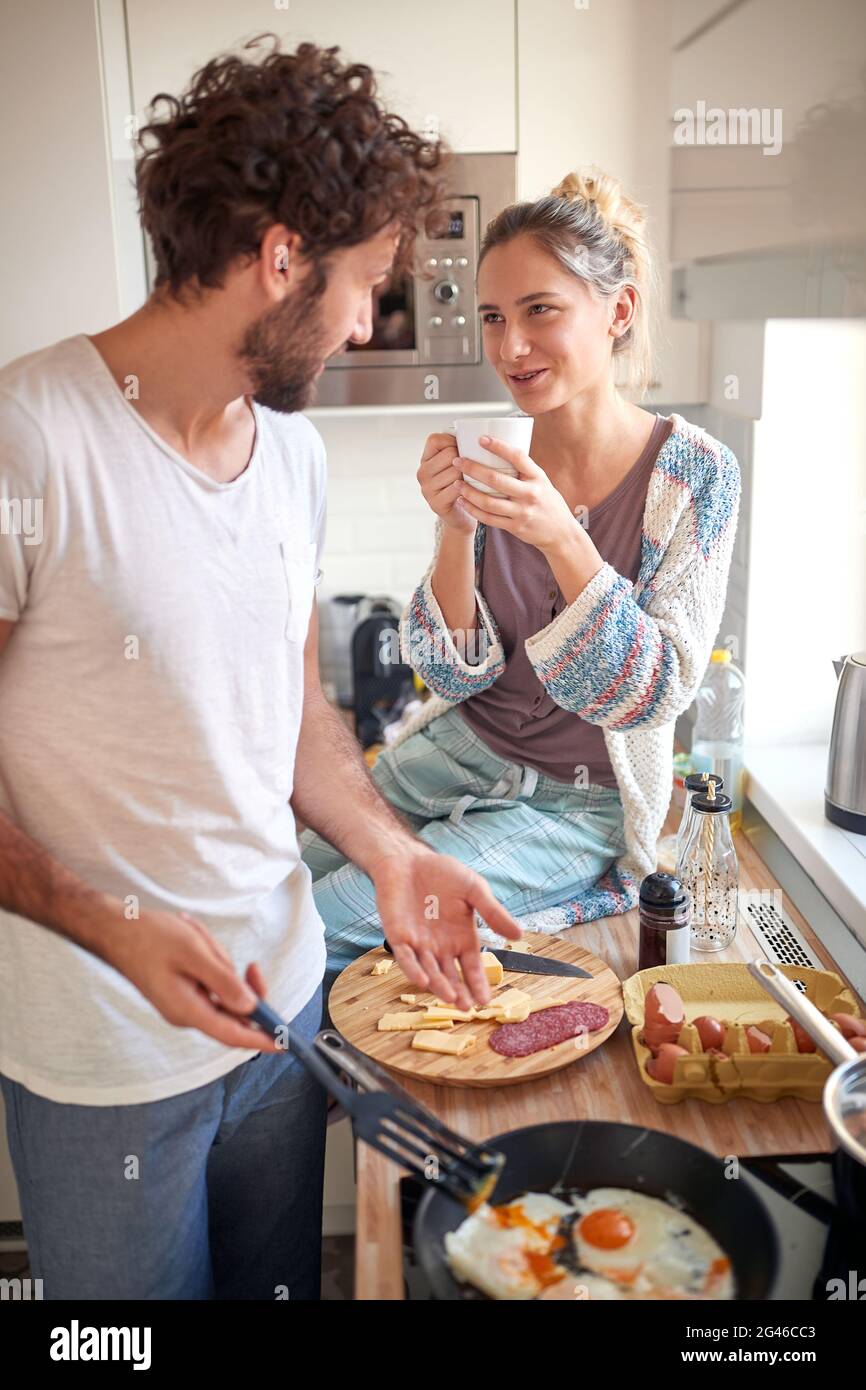 bella giovane coppia caucasica che fa colazione, bere caffè, parlare in cucina Foto Stock