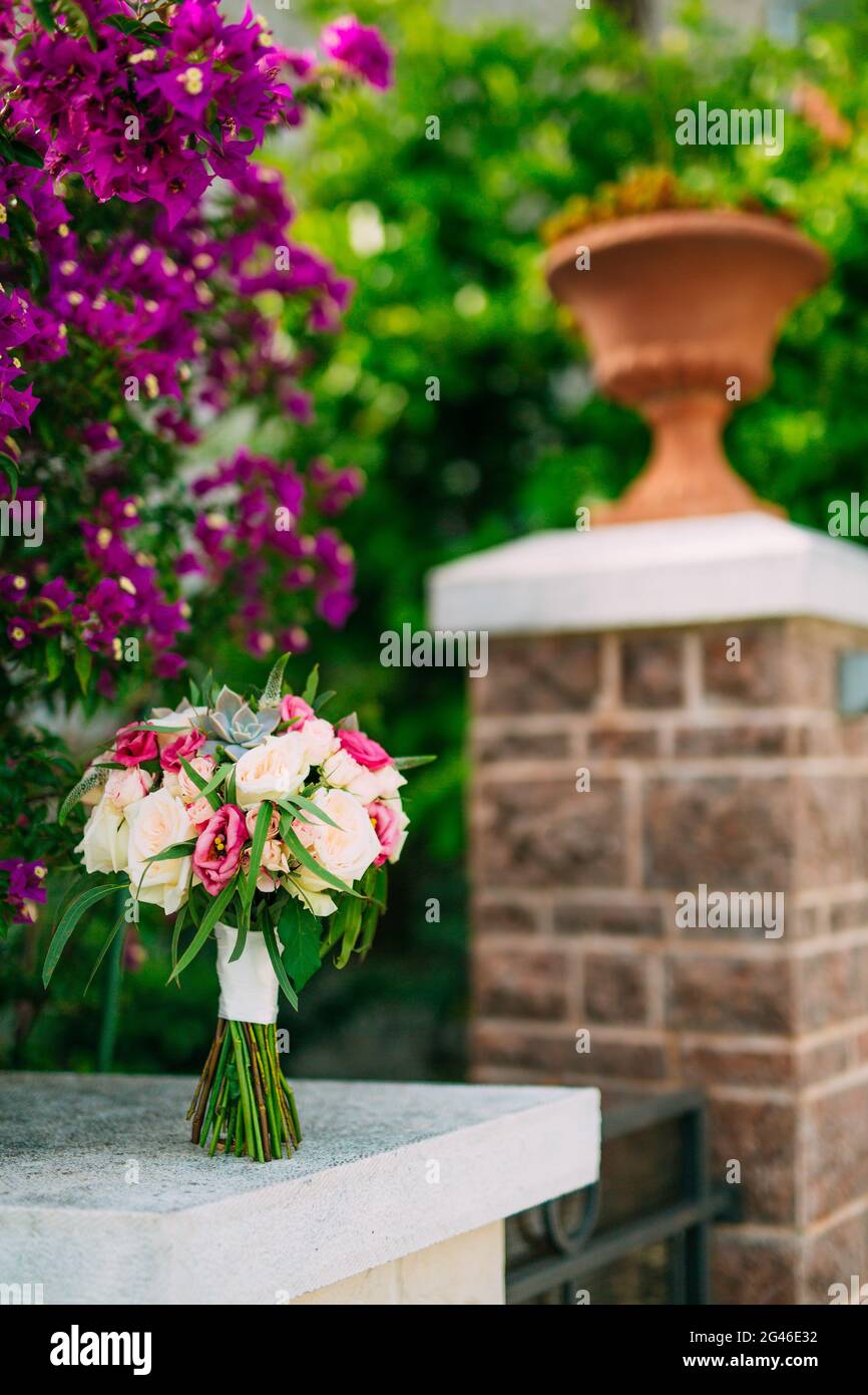 Bouquet di rose sullo sfondo di bougainvillea su pila di pietra Foto Stock