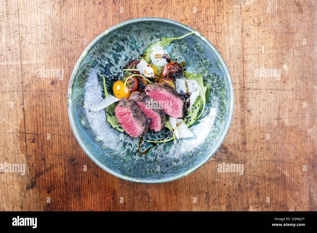 Tagliata di manzo italiana in stile moderno con bistecca di sidro affettato e insalata di agnello stagionato e servita come vista dall'alto in una ceramica di design Foto Stock