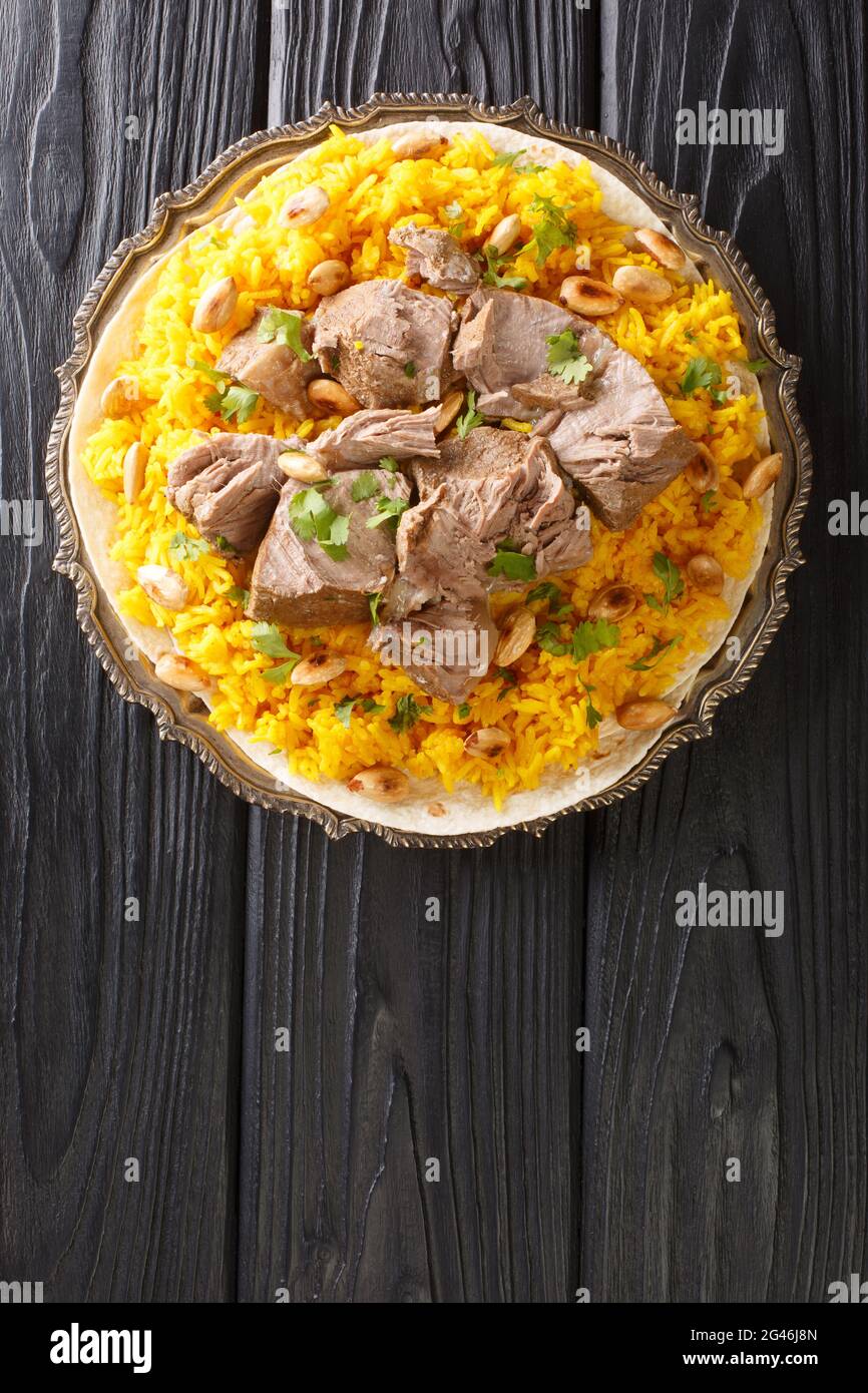 Il Mansaf è un piatto arabo tradizionale fatto di agnello cotto in una salsa di yogurt secco fermentato e servito con il chiodo di riso nel piatto sul tavolo. Ver Foto Stock