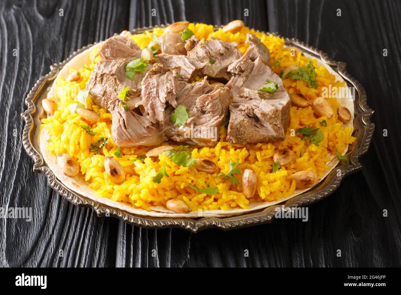 Jordan National Dish Mansaf fatto di carne di agnello yogurt magro, chiodo di riso nel piatto sul tavolo. Orizzontale Foto Stock