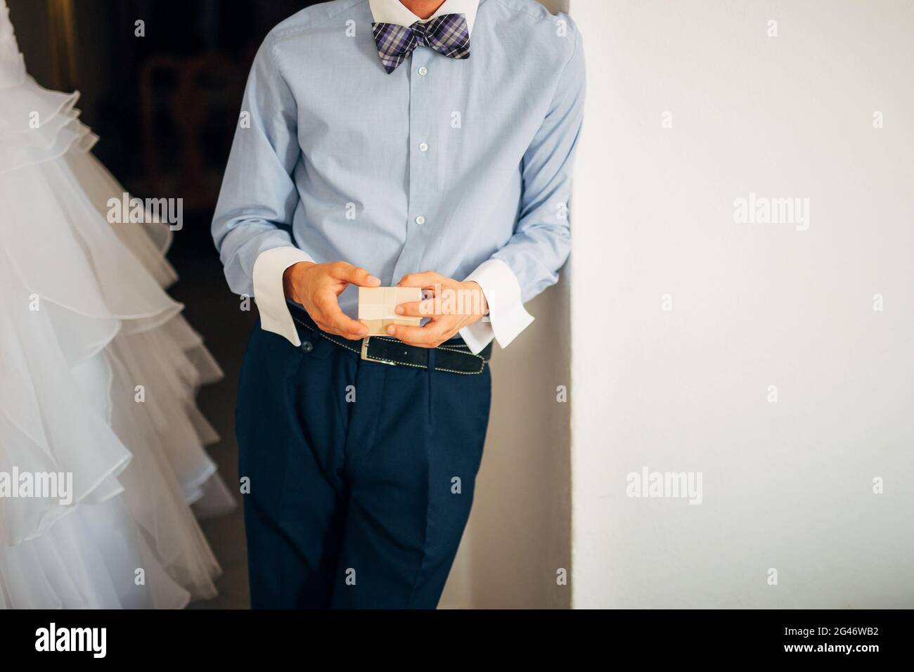 Un ragazzo in pantaloni e una maglietta detiene un dono nelle mani Foto Stock