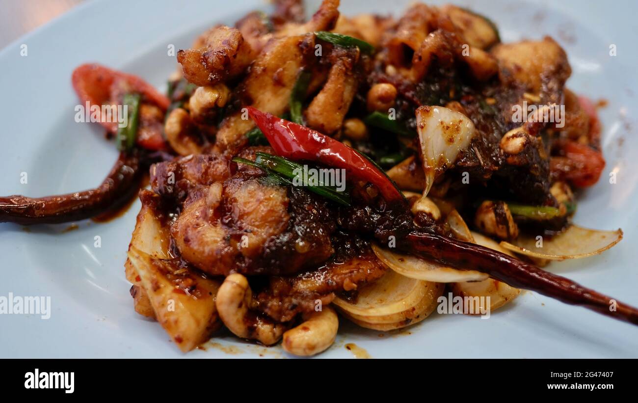 Prezzo economico tradizionale pollo alla noci di Cashew speziato Thai Food presso un ristorante cibo sul piatto basso budget pasto Foto Stock
