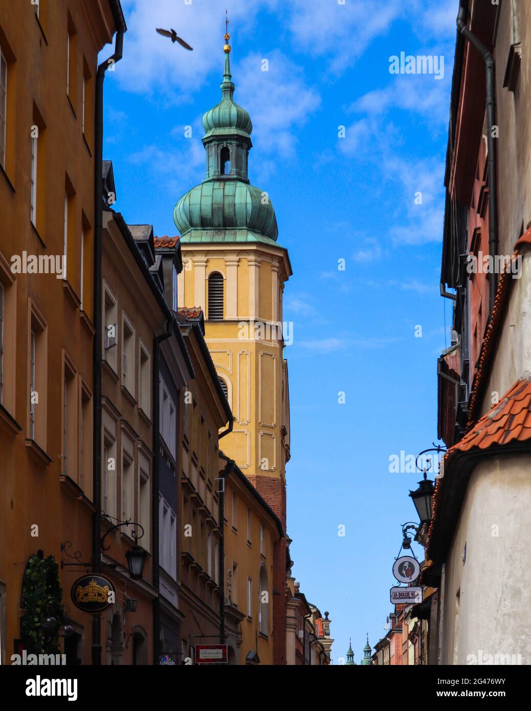 Tower con una guglia sulla strada di Varsavia, Polonia contro il cielo blu con nuvole Foto Stock