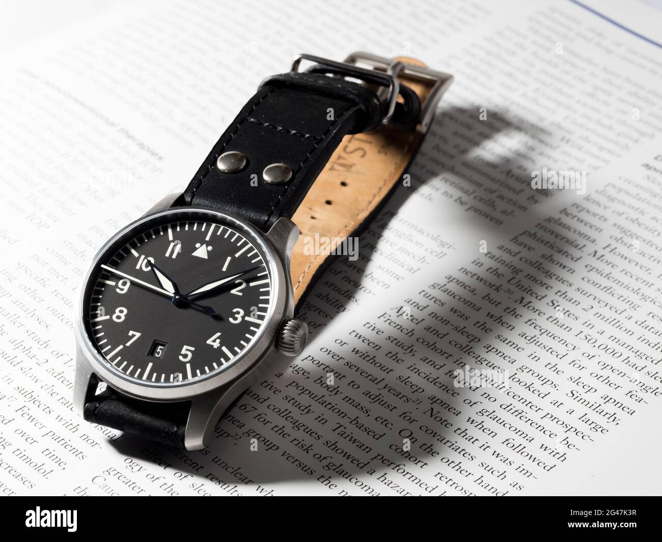 BANGKOK - AGOSTO 26: L'orologio pilota Stowa flieger è famoso ed eccellente orologio di qualità in Germania con giornale inglese carta sfondo fuoco selettivo Foto Stock