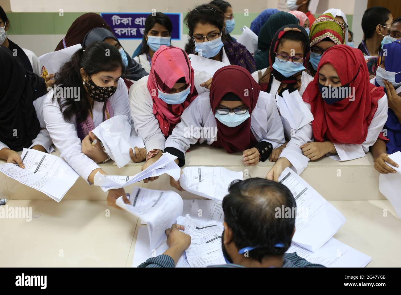 Sylhet, Bangladesh. 18 giugno 2021. Gli studenti di medicina stanno effettuando registrazioni spot presso il M. A. G. Osmani Medical College & Hospital vaccination center. La campagna cinese di vaccinazione contro il Sinopharm per vaccinare le persone è iniziata a livello nazionale. Foto Stock