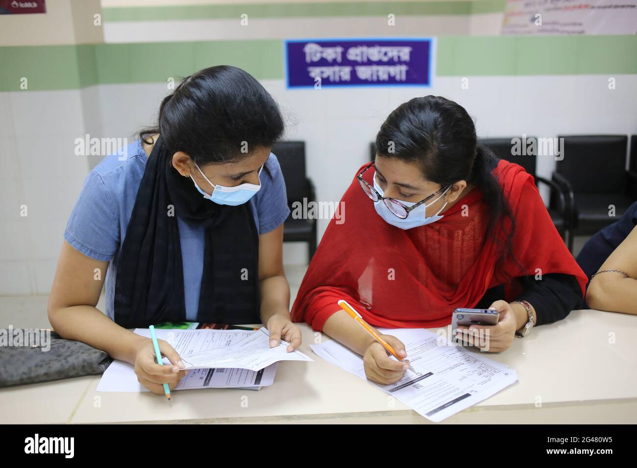 Sylhet, Bangladesh. 18 giugno 2021. Gli studenti di medicina stanno effettuando registrazioni spot presso il M. A. G. Osmani Medical College & Hospital vaccination center. La campagna cinese di vaccinazione contro il Sinopharm per vaccinare le persone è iniziata a livello nazionale. Foto Stock