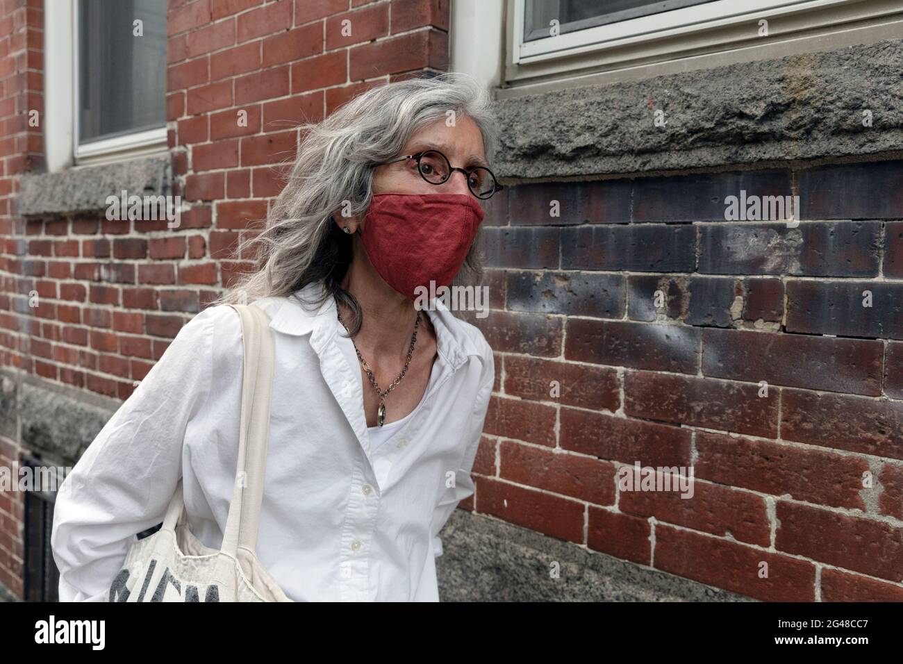 Donna che indossa una maschera protettiva Foto Stock