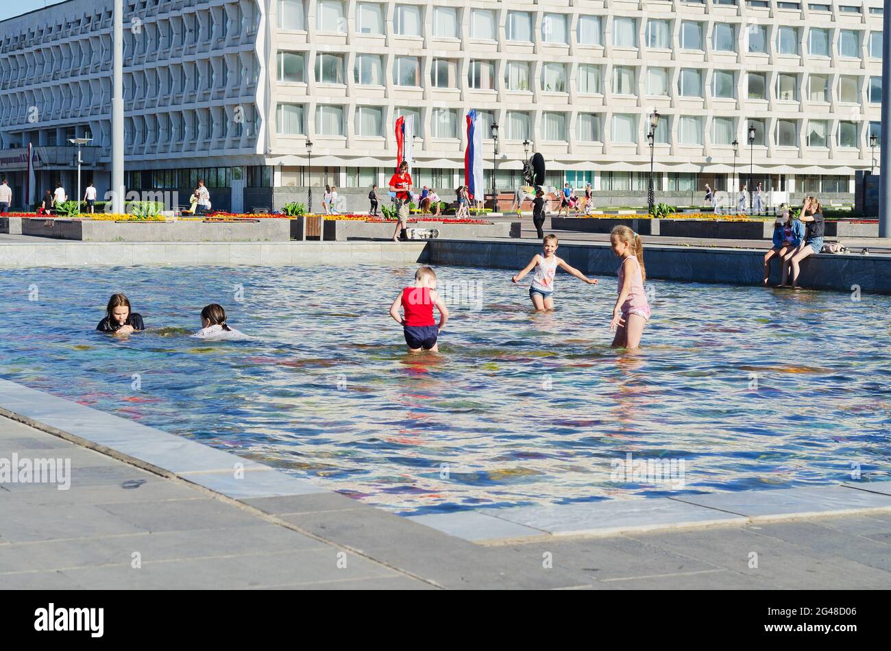 I bambini si divertono al caldo nella fontana a mosaico della città. Russia, Ulyanovsk, 19 giugno 2021 Foto Stock