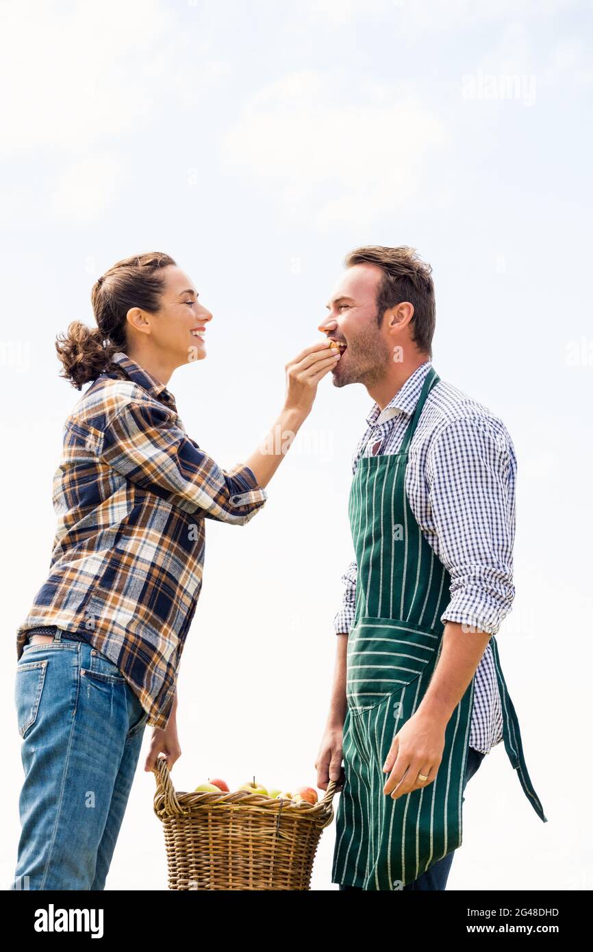 Donna sorridente che alimenta la mela all'uomo Foto Stock