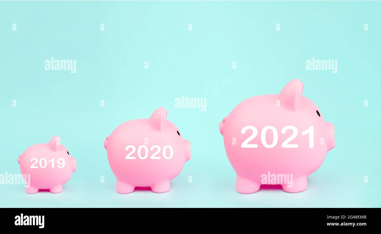 Pink piggy bank a forma di maiale con ologramma digitale 2021 anni segno su sfondo blu. Risparmio di denaro per investimenti futuri e concetto di pensionamento Foto Stock