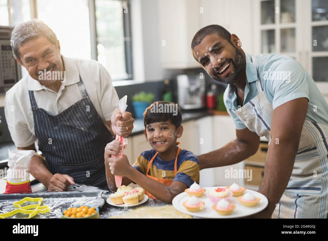 Ritratto di felice famiglia multigenerazionale che prepara insieme cibi dolci in cucina Foto Stock