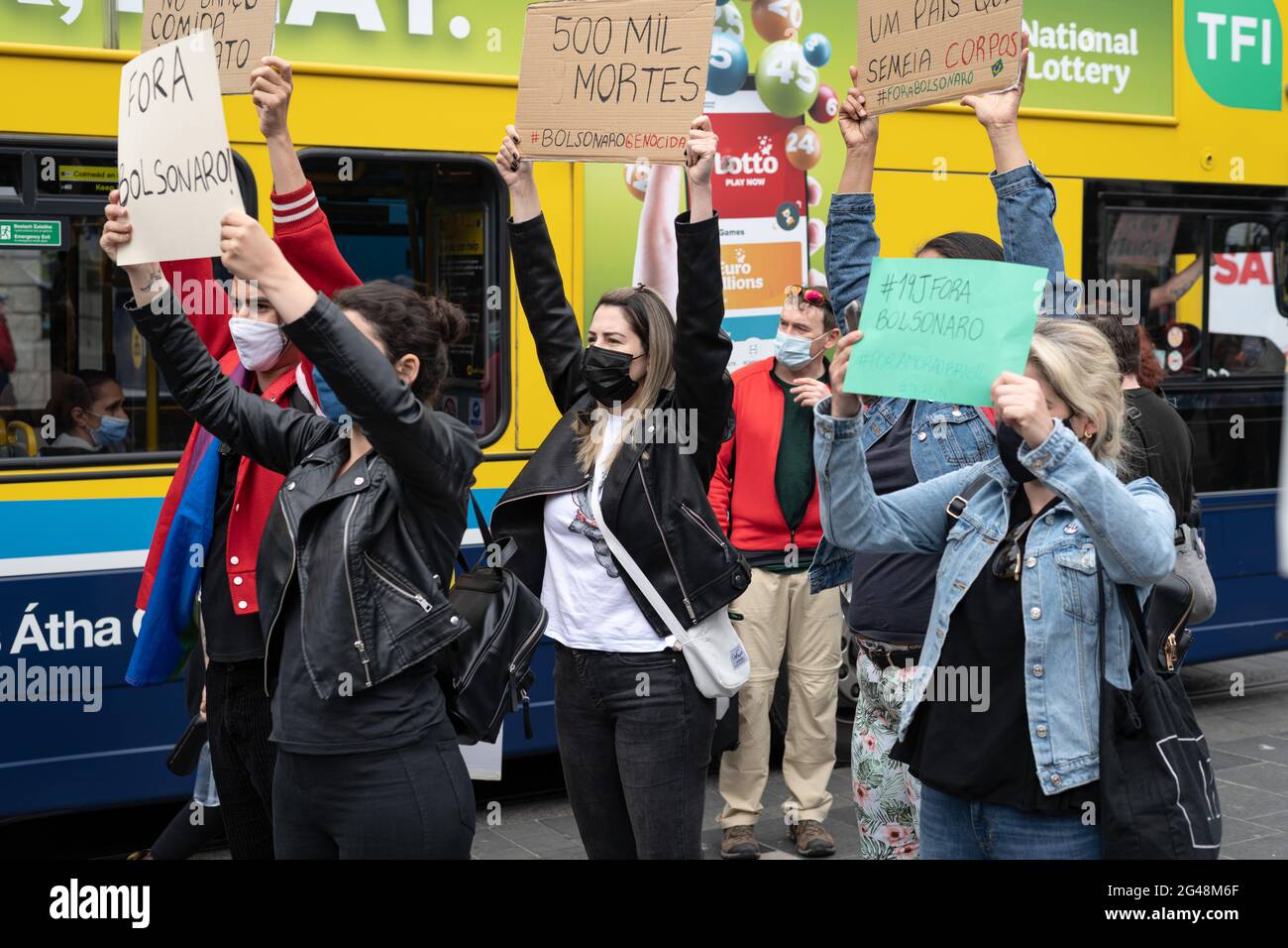 Manifestanti brasiliani che hanno in mano cartelli che esprimono la loro opinione, durante la manifestazione. Un certo numero di manifestanti, per la maggior parte della diaspora brasiliana a Dublino, si sono riuniti di fronte al GPO (Ufficio postale Generale) in via o'Connell manifestando contro il presidente brasiliano, Jair Bolsonaro e la sua gestione della pandemia del Covid 19 chiedendo l'impeachment di Bolsonaro e per la fornitura di vaccinazioni. Anche Gino Kelly, TD (membro del Parlamento irlandese) del Partito popolare prima del profitto ha tenuto un discorso che dimostra la solidarietà irlandese al movimento. Foto Stock