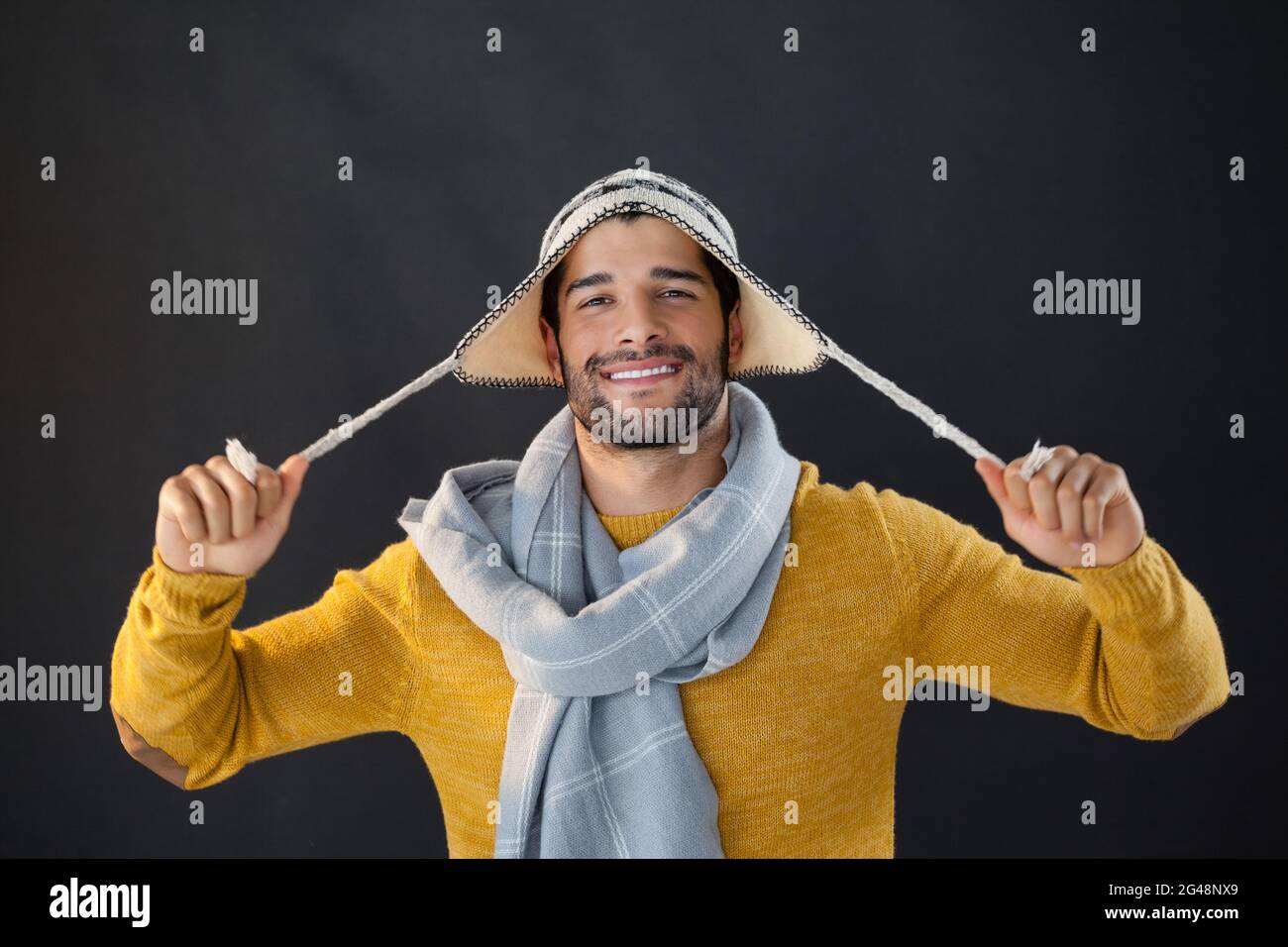 Ritratto di uomo sorridente che tiene il cappello di lana Foto Stock