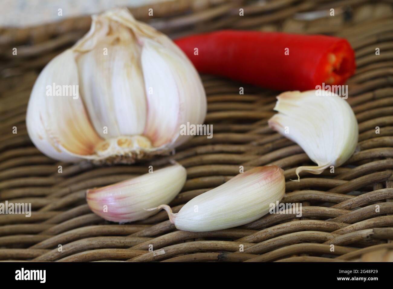 Spicchi di aglio fresco su vassoio di vimini, guardaroba Foto Stock