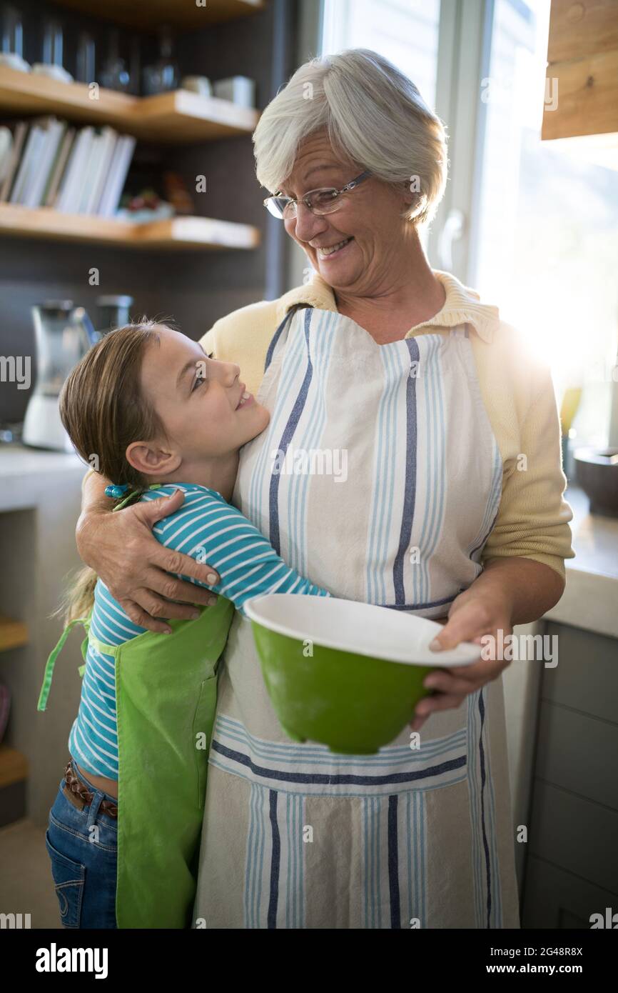 Nonna e nipote abbracciano in cucina Foto Stock