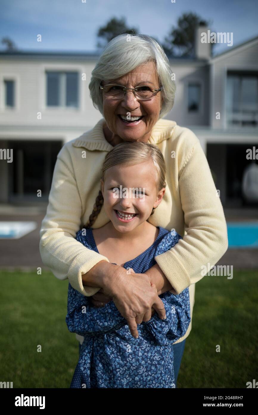 Nonna e nipote sorridenti che si abbracciano in giardino Foto Stock