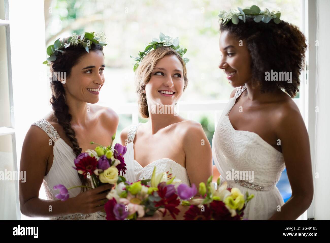 Sposa e bridesmaid in piedi con bouquet Foto Stock