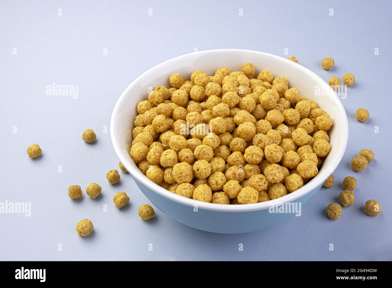 Palle di mais nel recipiente su sfondo bianco Foto Stock