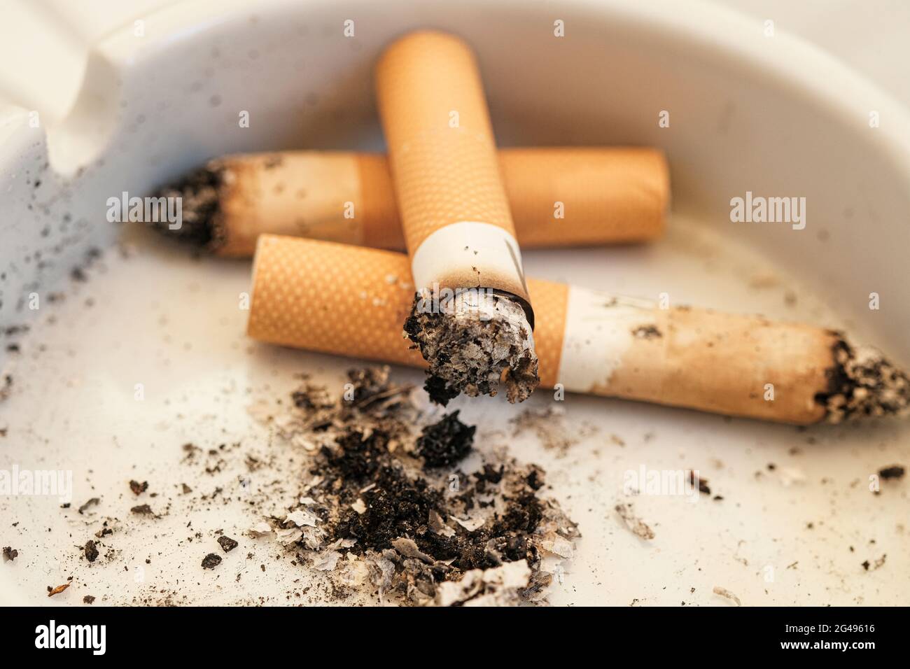 Bruciando i butt di sigaretta, lo spreco di tabacco, dipendenza di fumo, vita malsana Foto Stock