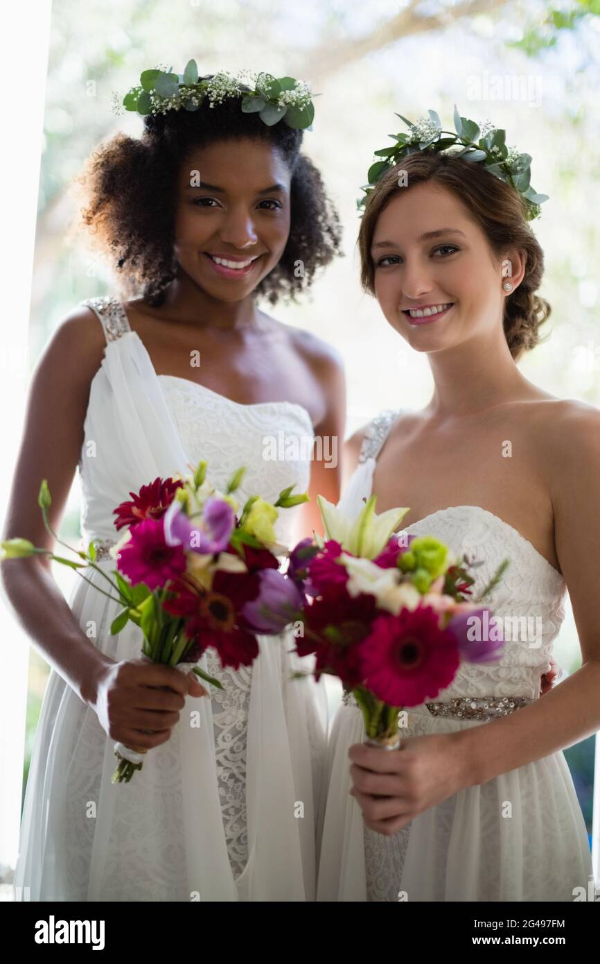 Sposa e le sue damigelle hanno piedi con bouquet a casa Foto Stock