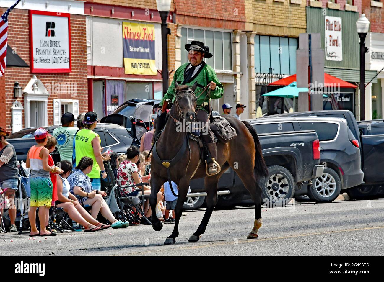 Un membro del Council Grove Regulators in costume completo, tra cui un paio di sei pistole, cavalca il suo cavallo nella sfilata dei giorni di Washunga Foto Stock