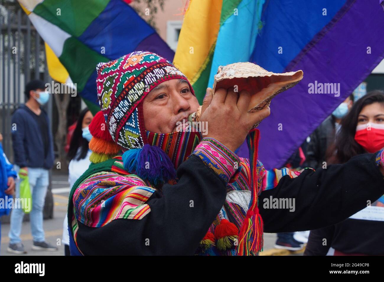 Un uomo indigeno che gioca un pututu (guscio) quando migliaia scese in strada chiedendo il riconoscimento di Pedro Castillo come vincitore del runoff presidenziale. Foto Stock