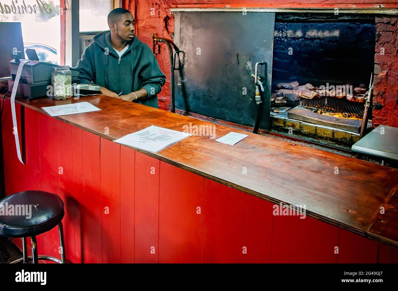 Un dipendente guarda le costolette fumate ad Archibald’s, 15 marzo 2014, a Northport, Alabama. Foto Stock