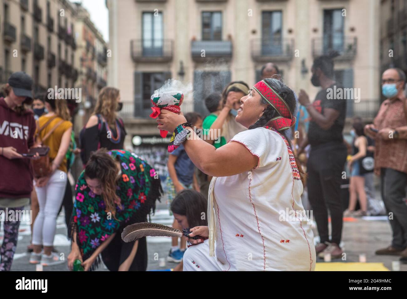 Barcellona, Spagna. 19 giugno 2021. Una donna esegue la cerimonia di purificazione maya durante la manifestazione. UN gruppo messicano che pratica rituali maya pre-ispanici ha tenuto una cerimonia di purificazione per la Colombia, di fronte al municipio di Barcellona, su invito di gruppi di colombiani di Barcellona che hanno manifestato contro il presidente colombiano, Ivan Duque Marquez, Il suo governo e a sostegno dello 'sciopero civico indefinito' e delle proteste nel paese che hanno avuto inizio il 28 aprile 2021. Credit: SOPA Images Limited/Alamy Live News Foto Stock