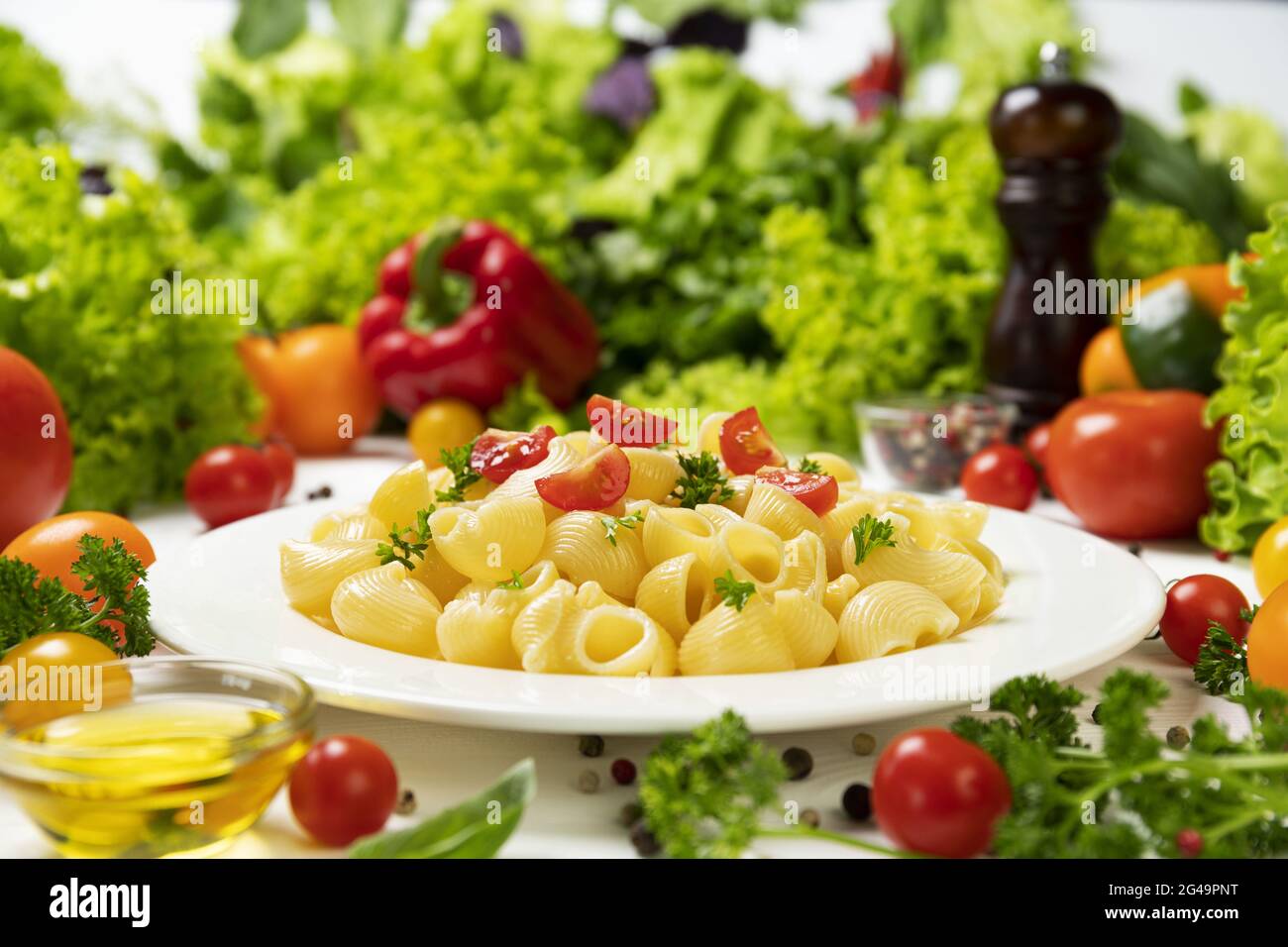 Pasta rigata italiana con pomodori e foglie di basilico Foto Stock
