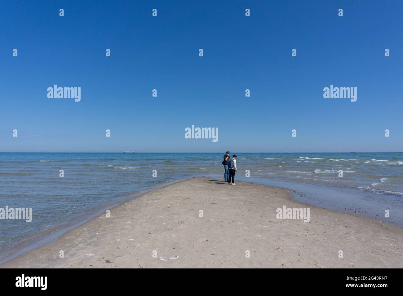 Una coppia che si trova all'estremità settentrionale della Danimarca, dove il Mar Baltico e il Mare del Nord si incontrano a Skagen Reef Foto Stock