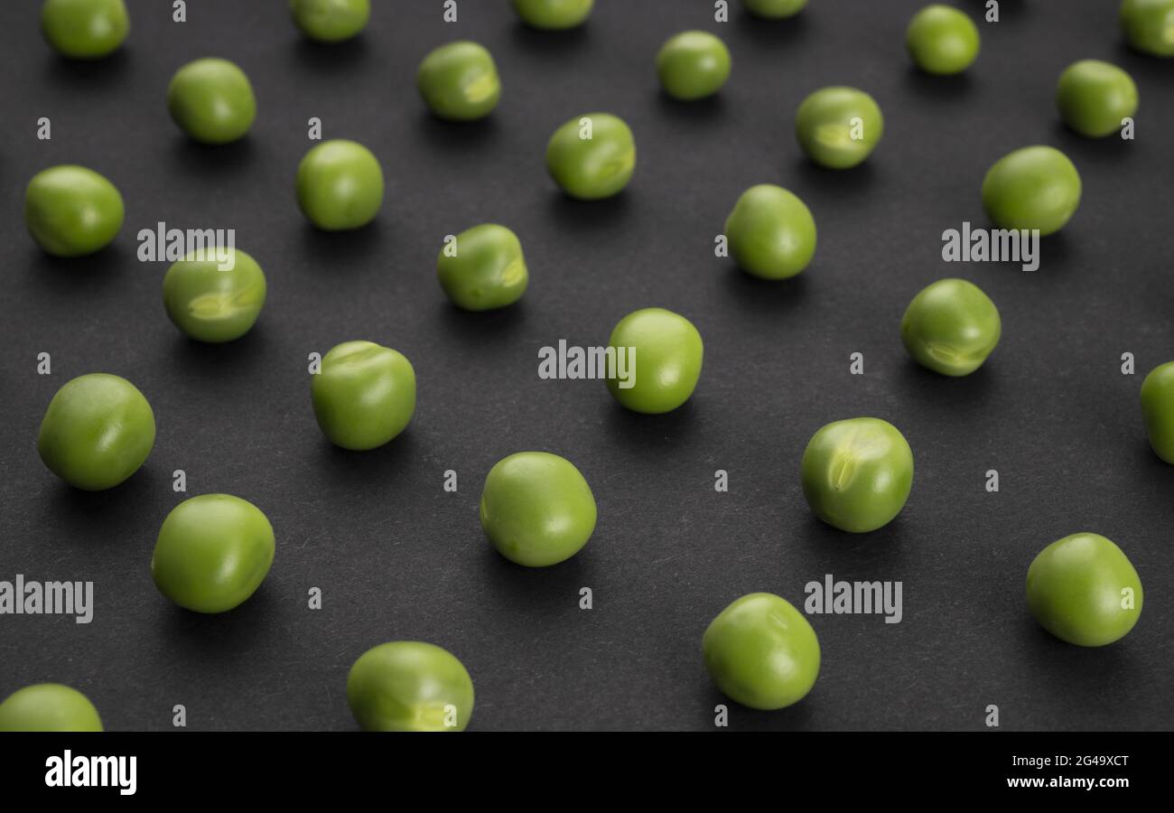 Modello di piselli verdi su sfondo nero Foto Stock