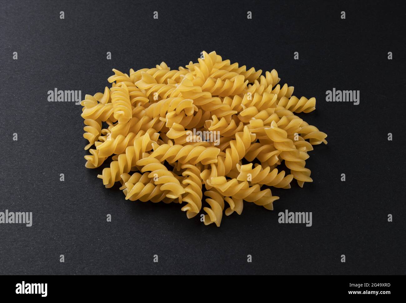 Pasta di fusilli grezza isolata su fondo nero Foto Stock