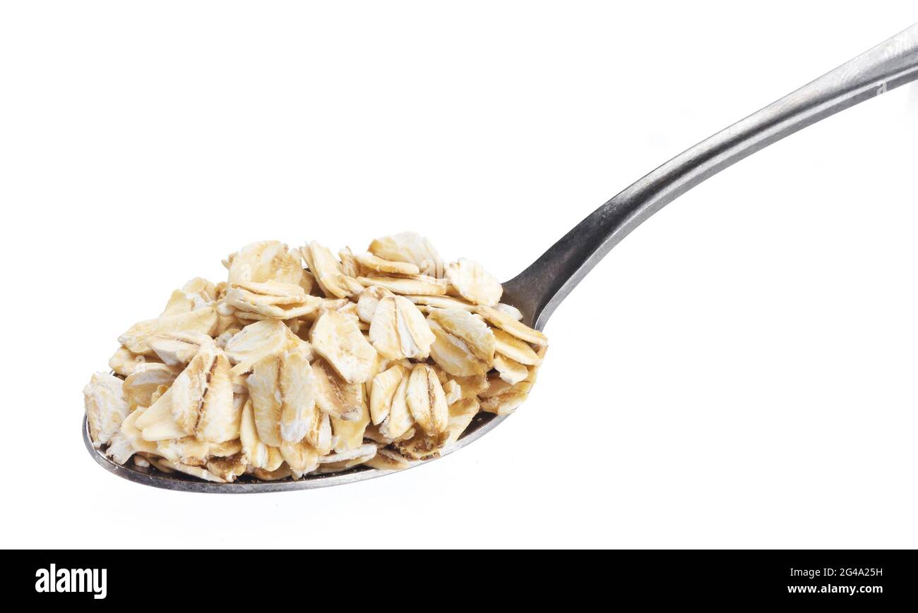 Farinata d'avena. OAT flakes in cucchiaio isolato su sfondo bianco Foto Stock