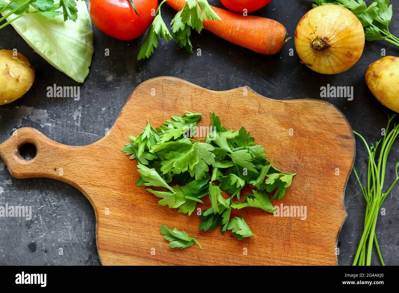 Cottura graduale di zuppa di pomodoro o borscht. Tagliando le verdure, prezzemolo tritato. Ingredienti. Vista dall'alto. Foto Stock
