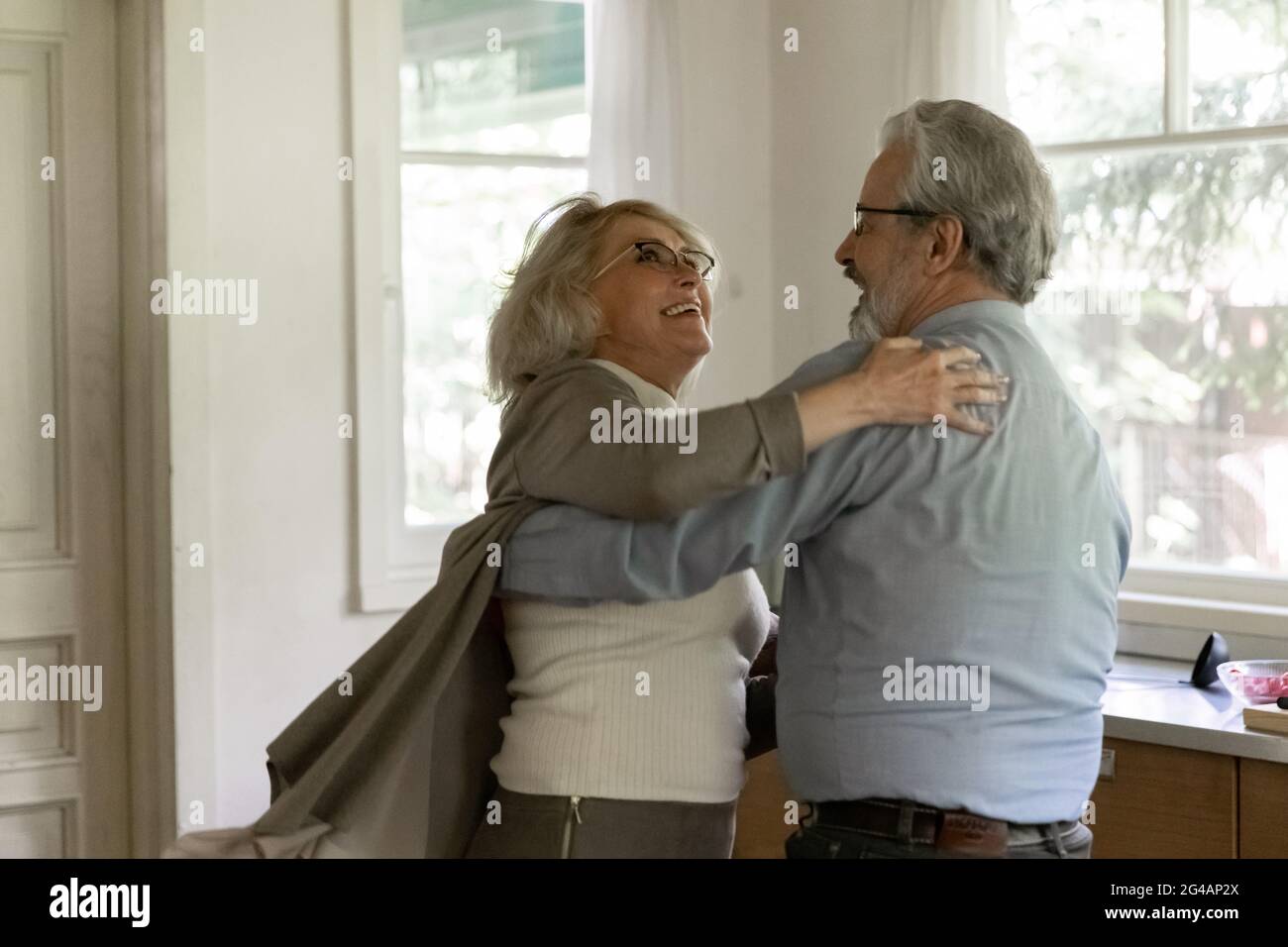 Sorridente anziano e donna ballano insieme a casa Foto Stock