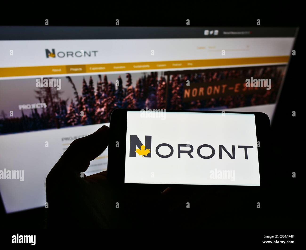 Persona che tiene il telefono mobile con il logo della società mineraria canadese Noront Resources Ltd. Sullo schermo davanti alla pagina web. Mettere a fuoco il display del telefono. Foto Stock