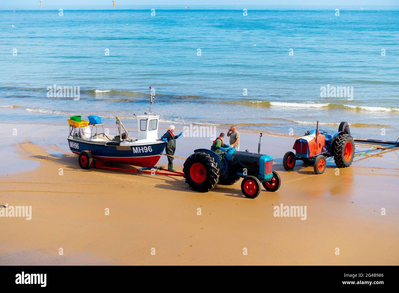 Granchio o Lobster, pescatore che guida un trattore che trasporta la loro barca fuori dal mare fermandosi a chiacchierare con un altro pescatore Redcar Cleveland UK Foto Stock