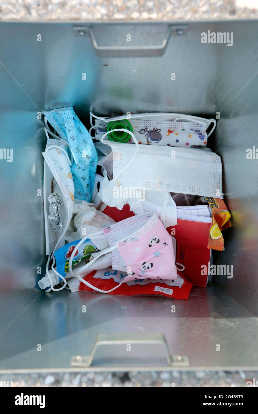 Covid protezione del viso nella spazzatura può di fronte alla scuola elementare Foto Stock