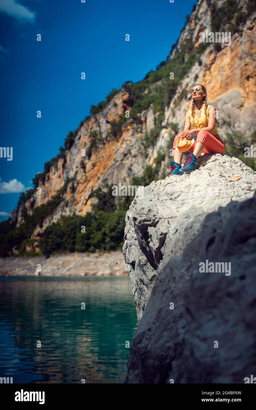 Donna seduta su rocce sopra la gola del Mont Rebei in Catalogna Foto Stock