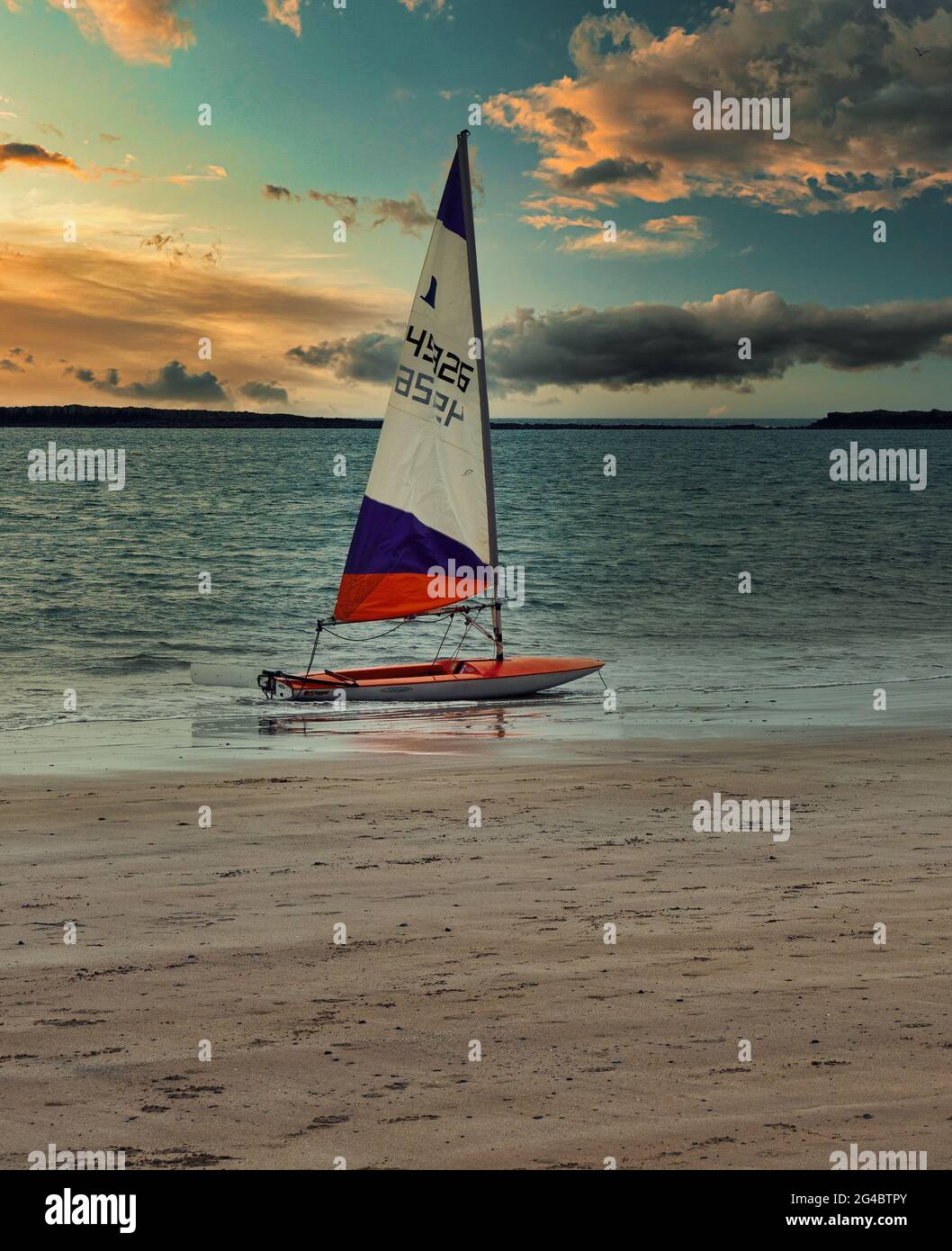 Una dinghy di vela del topper al bordo del mare dopo una giornata di divertimento di vela. Fotografia scattata su Embleton Bay Beach, Northumberland. Foto Stock