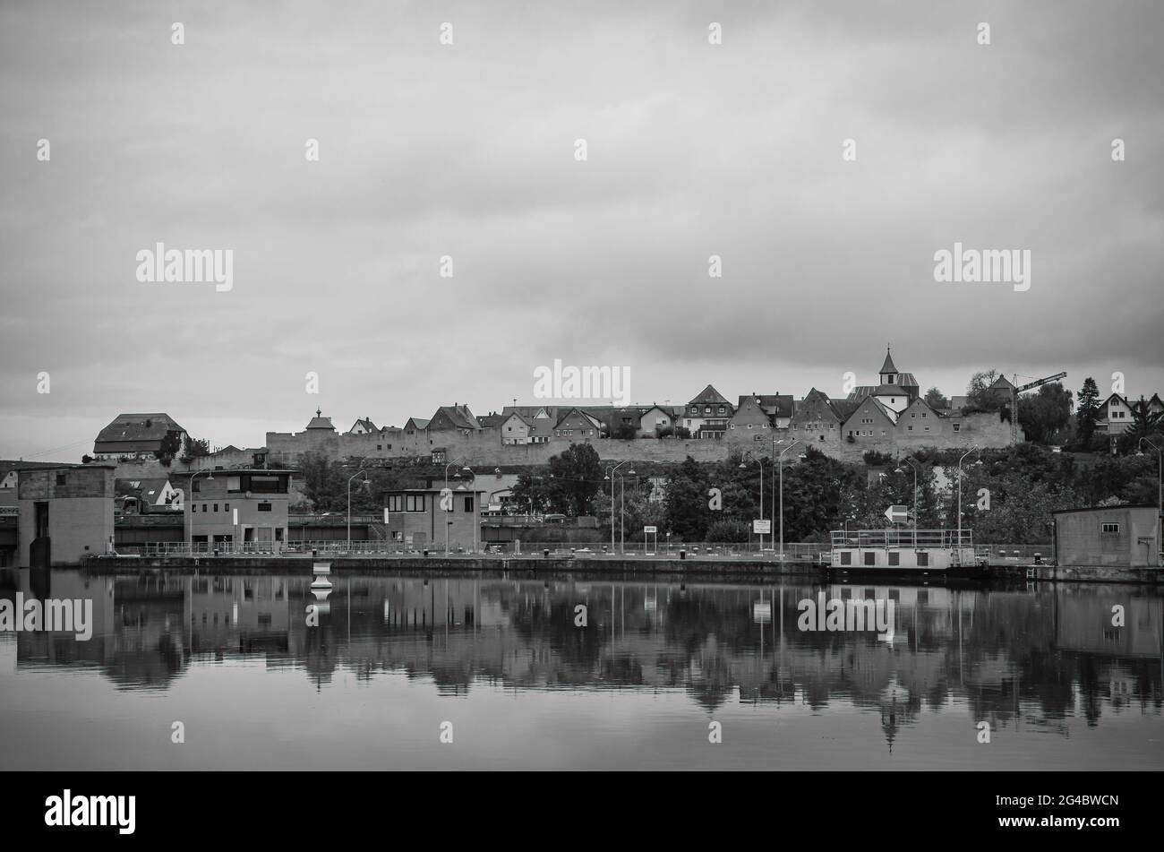 Lauffen am Neckar, Baden-Württemberg, Germania: Diga e serratura nel fiume Neckar con la sagoma della città medievale muro sul retro. Foto Stock