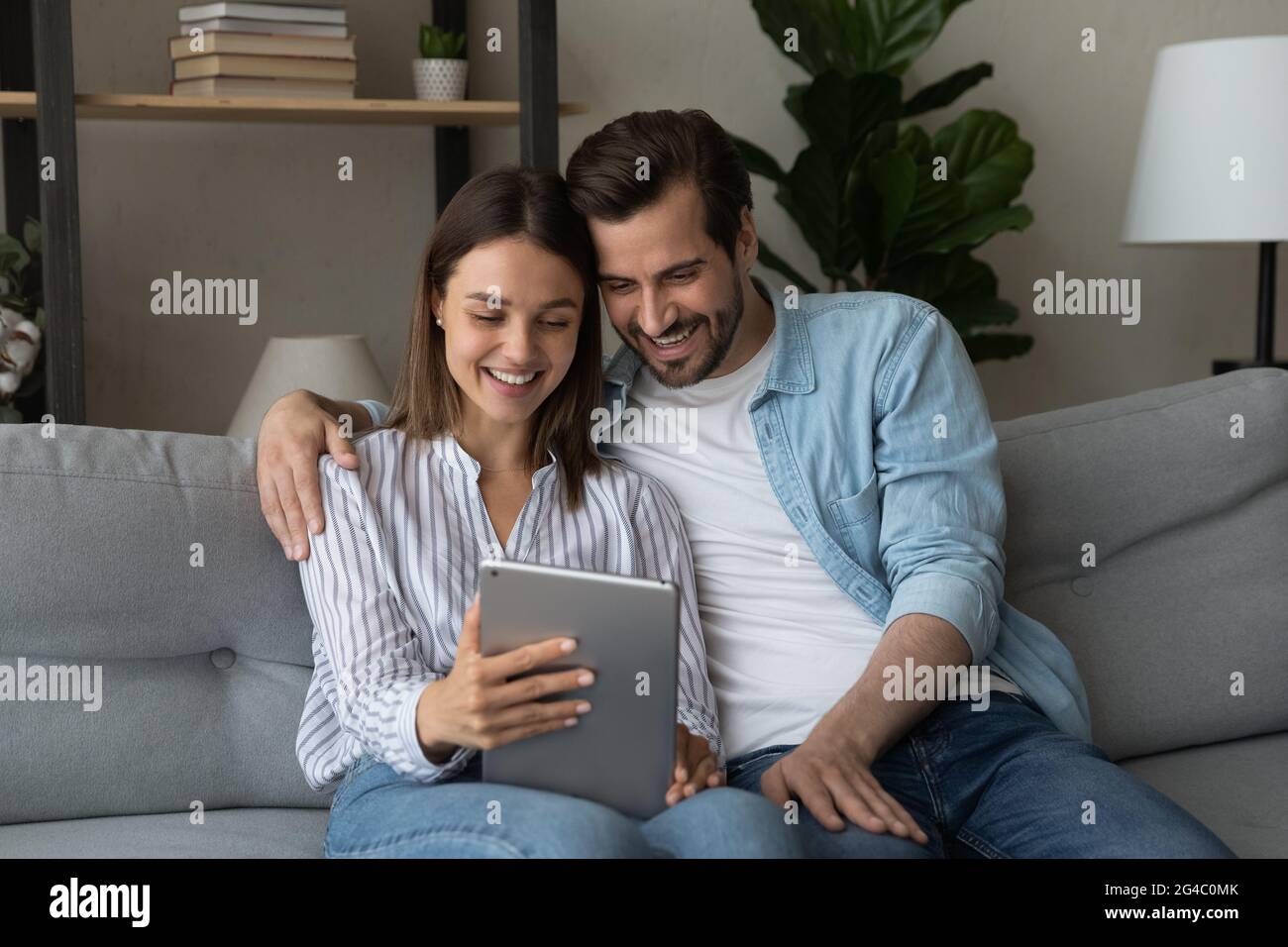 Sorridente giovane coppia che utilizza un tablet per computer digitale. Foto Stock