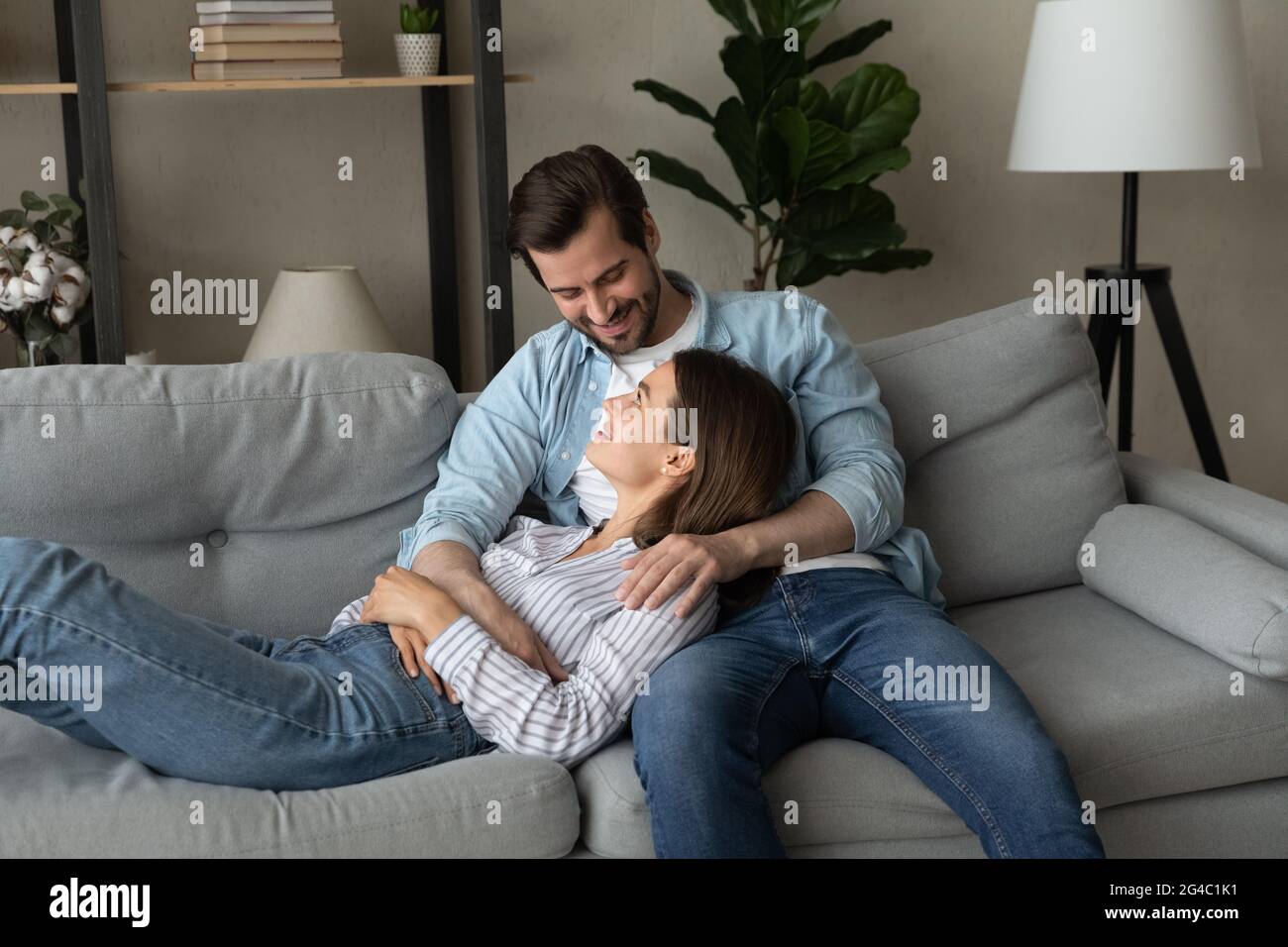 Buon legame giovane coppia di famiglia che riposa sul divano comodo. Foto Stock