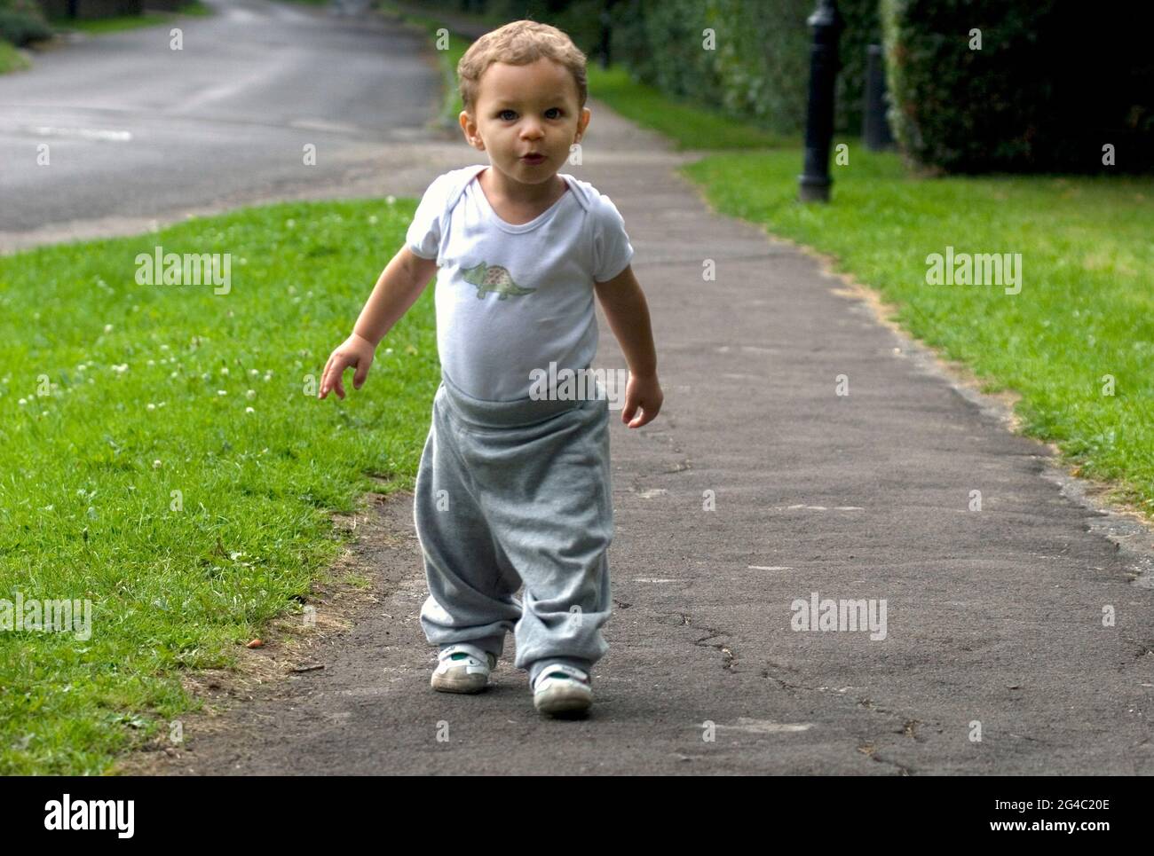 felice bambino piccolo che prende i suoi primi passi all'aperto Foto Stock