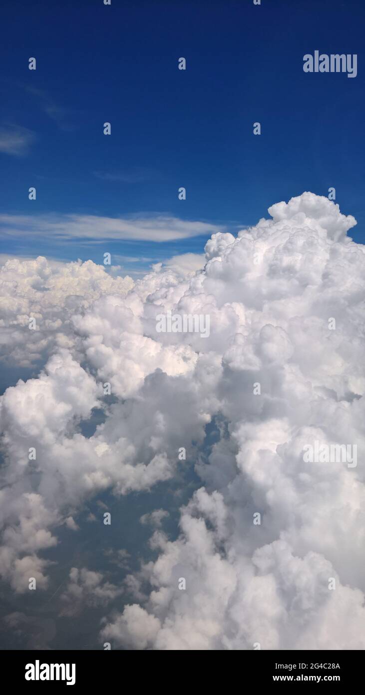 Splendide nuvole bianche e nuvole pluviali con vista cielo blu da un aereo, si affacciano sull'isola di Pulau Tinggi, Malesia Foto Stock