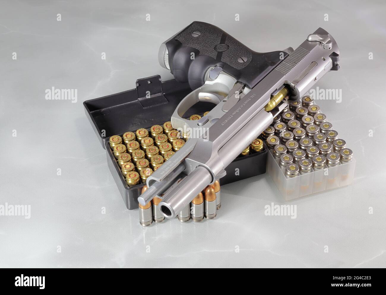 Beretta 92FS o M9 apertura del vetrino con pistola manuale e confezione di pallottole da 9 mm con parabellum isolato sulla superficie di riflessione. Foto Stock
