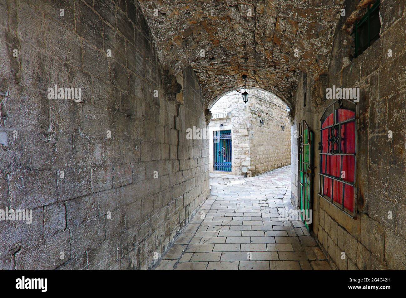 Strada stretta con arco e porte colorate e serrande nella città vecchia di Cattaro, Montenegro Foto Stock