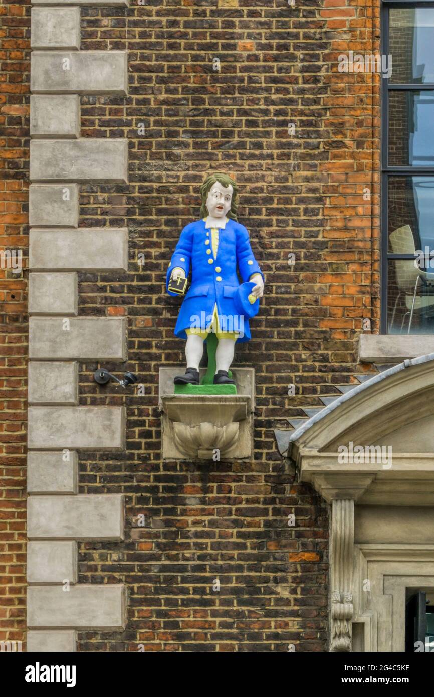 Statua di scolaro fuori dall'ingresso della vecchia scuola di beneficenza di St Andrews Parochial a Hatton Garden, Londra. Foto Stock