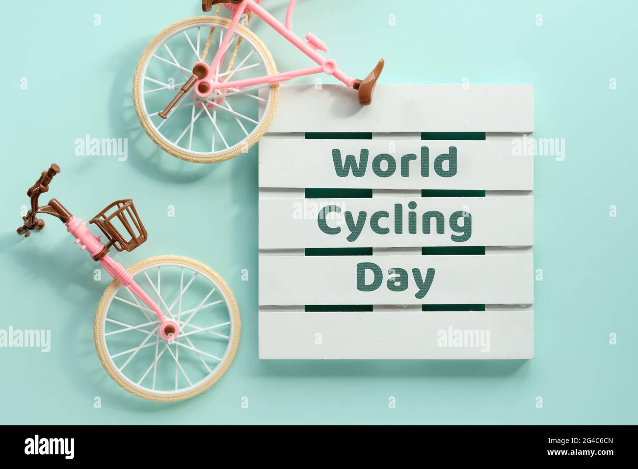 Giornata mondiale delle biciclette, giornata delle biciclette il 3 giugno. Giocattolo modello di bici da città con ombra su sfondo blu menta. Disposizione piatta, vista dall'alto, concetto rétro vintage minimal Foto Stock